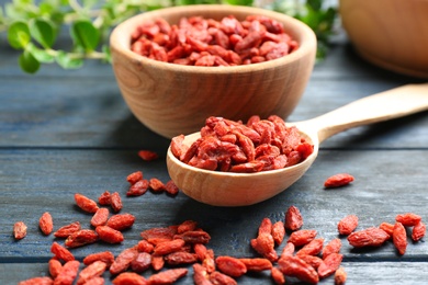 Photo of Composition with dried goji berries on  blue wooden table, closeup. Healthy superfood