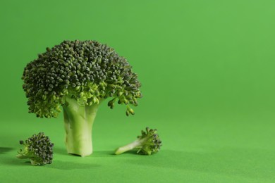 Photo of Fresh raw broccoli on light green background. Space for text