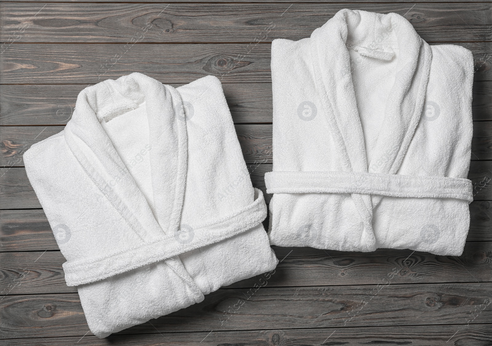 Photo of Flat lay composition with folded bathrobes on wooden background