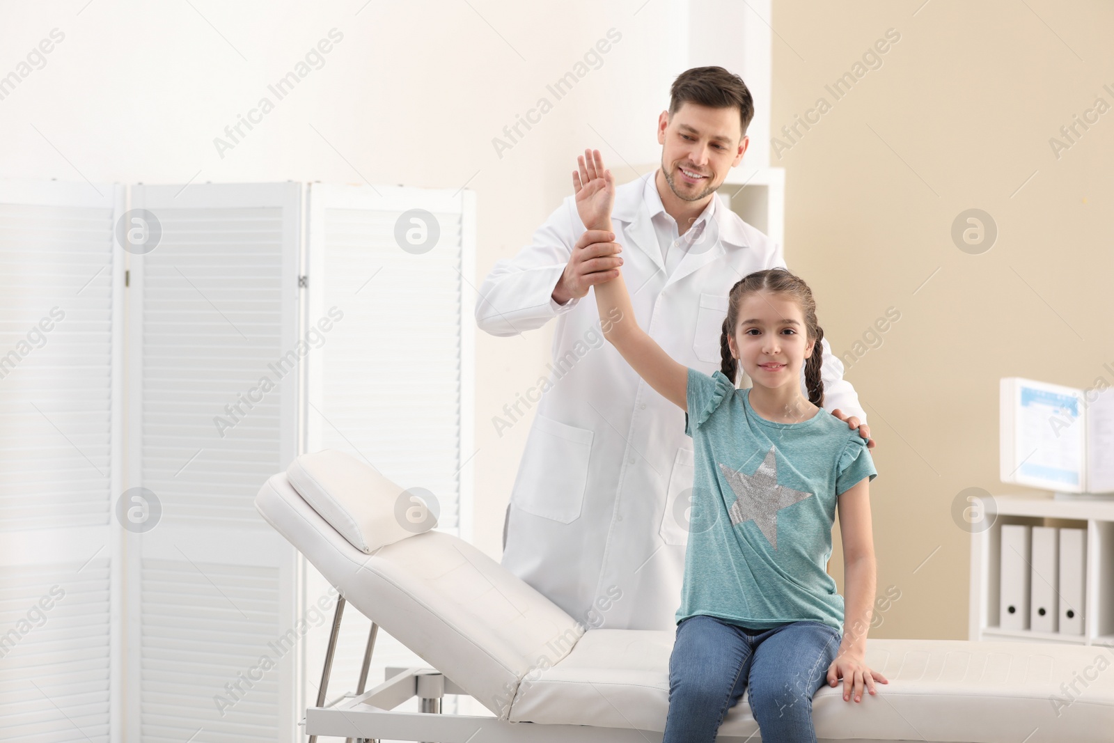 Photo of Chiropractor examining child with back pain in clinic