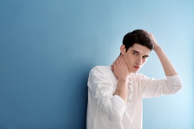 Portrait of young man with beautiful hair on color background