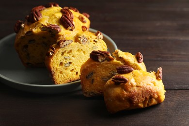 Photo of Delicious pumpkin bread with pecan nuts on wooden table