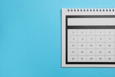 Paper calendar on light blue background, top view. Space for text