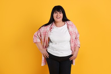 Photo of Beautiful overweight mature woman with charming smile on yellow background