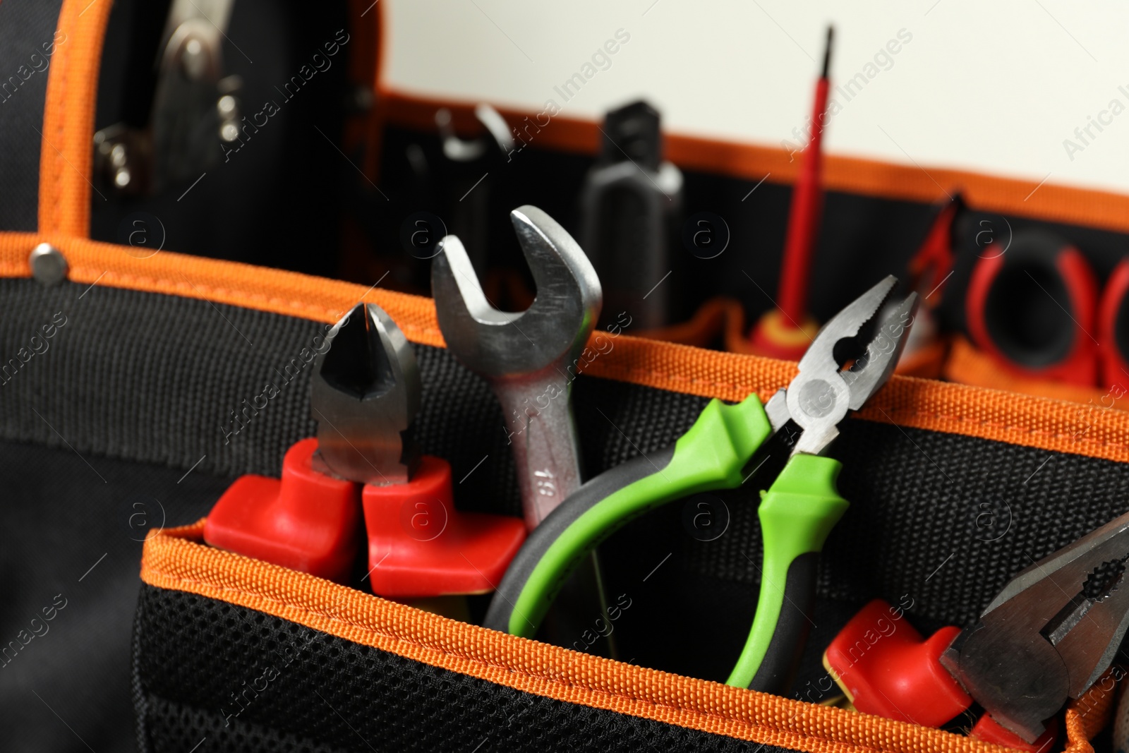 Photo of Bag with different pliers, wrench and other tools for repair, closeup