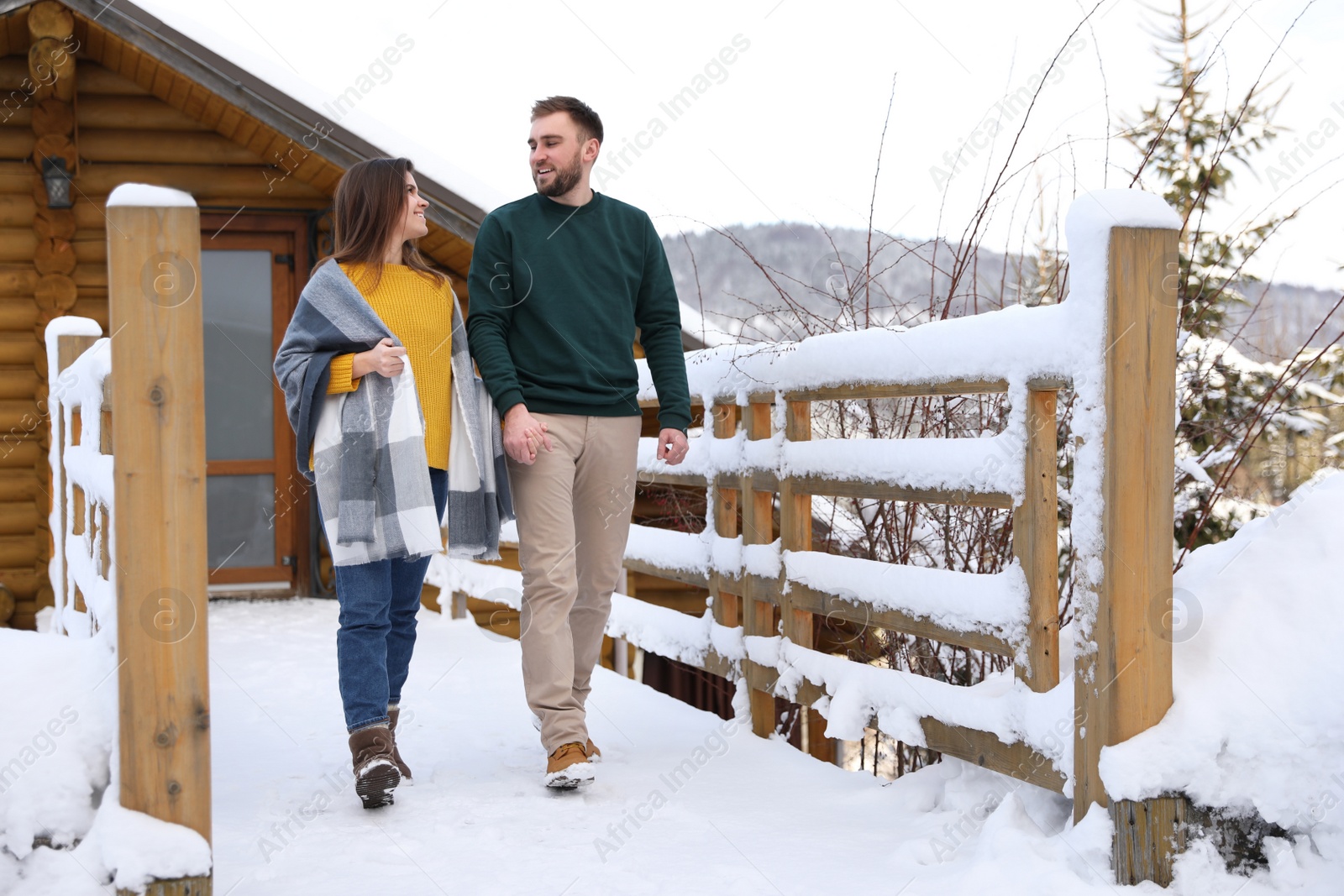 Photo of Lovely couple walking together on snowy day. Winter vacation