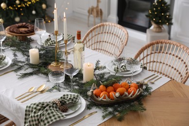 Christmas table setting with festive decor and dishware in room