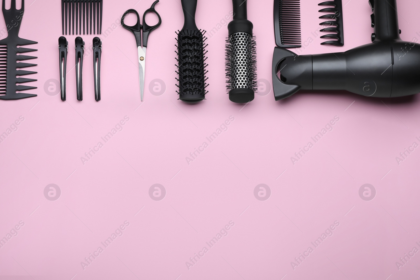 Photo of Flat lay composition with modern hair dryer on pink background, space for text