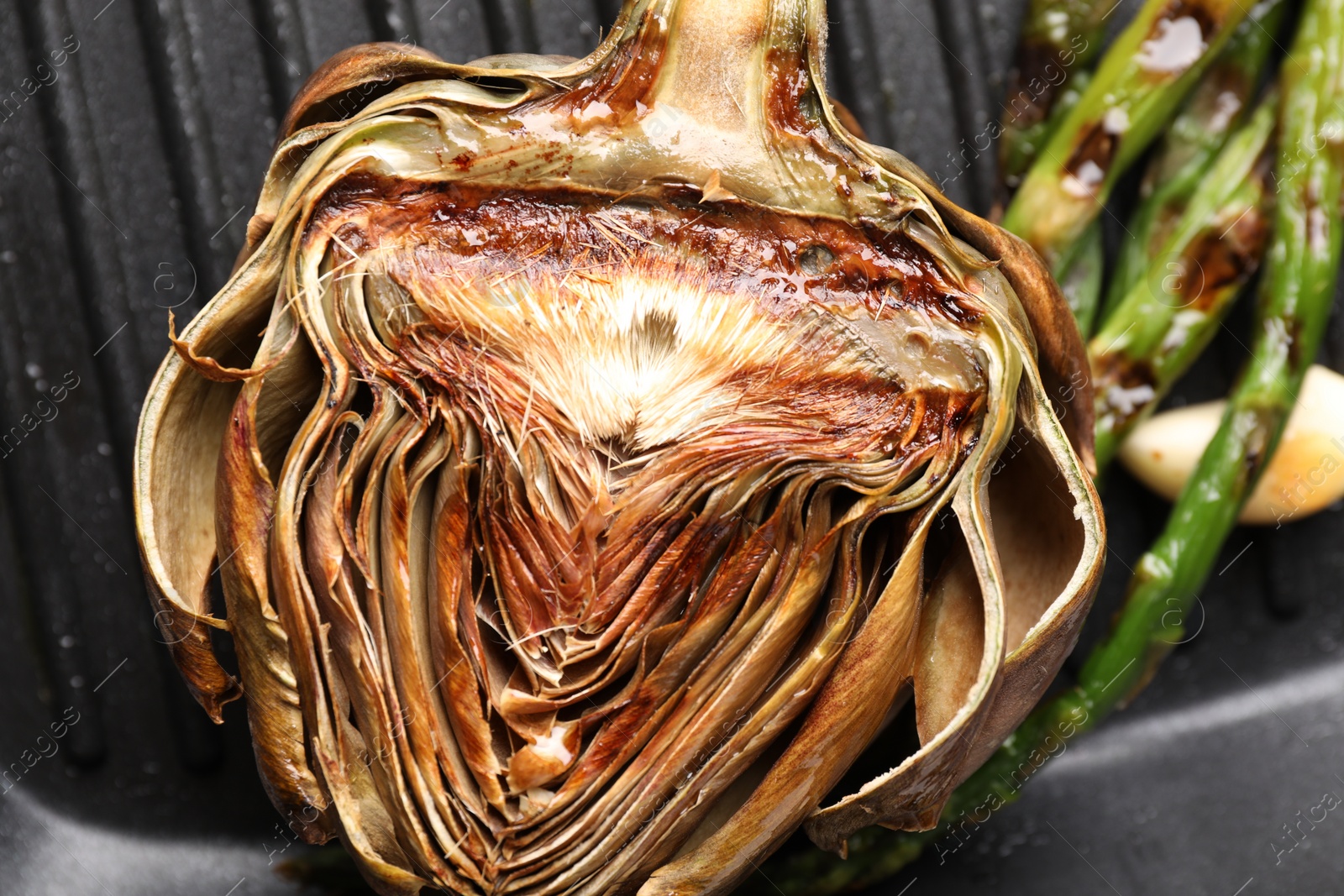 Photo of Pan with tasty grilled artichoke, closeup view