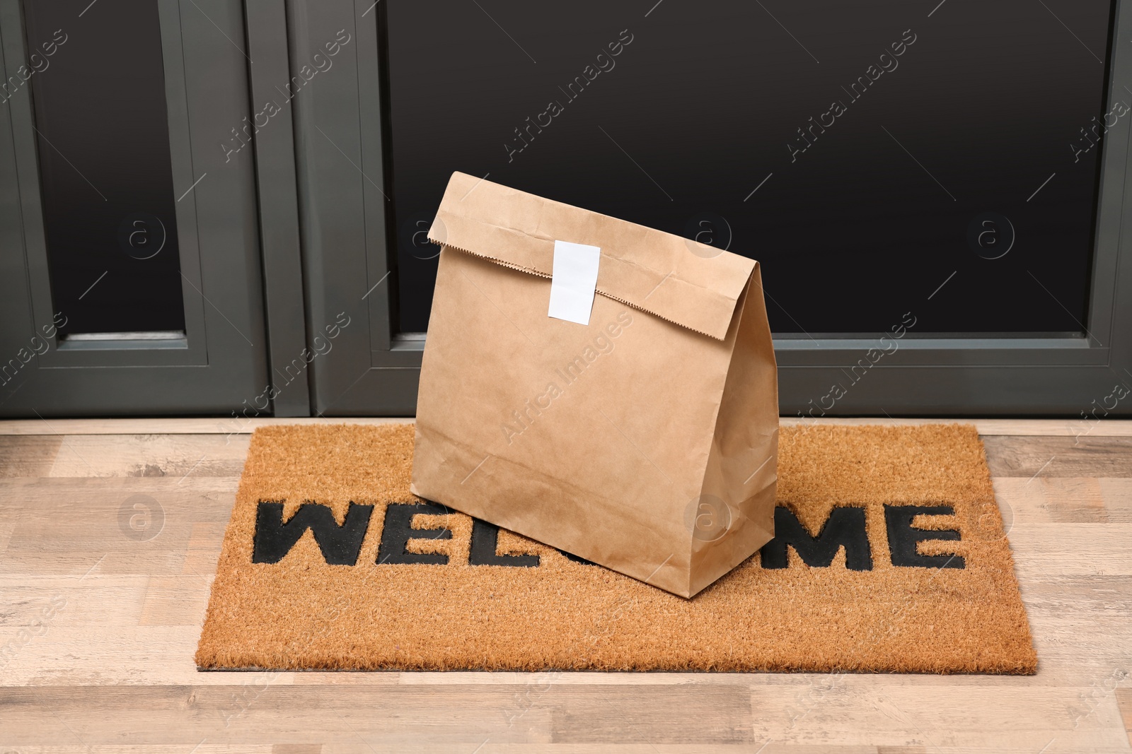 Photo of Paper bag on door mat near entrance indoors