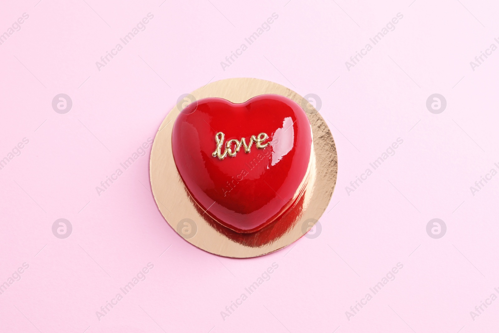 Photo of St. Valentine's Day. Delicious heart shaped cake on light pink background, top view