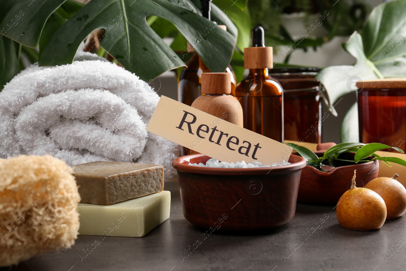 Photo of Card with word Retreat and different spa products on grey table