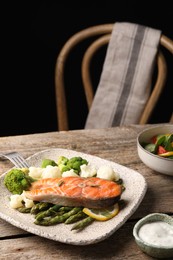 Photo of Healthy meal. Tasty grilled salmon with vegetables served on wooden table