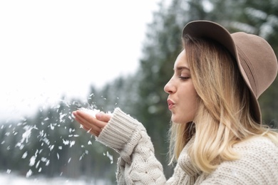 Young woman playing with snow outdoors. Winter vacation