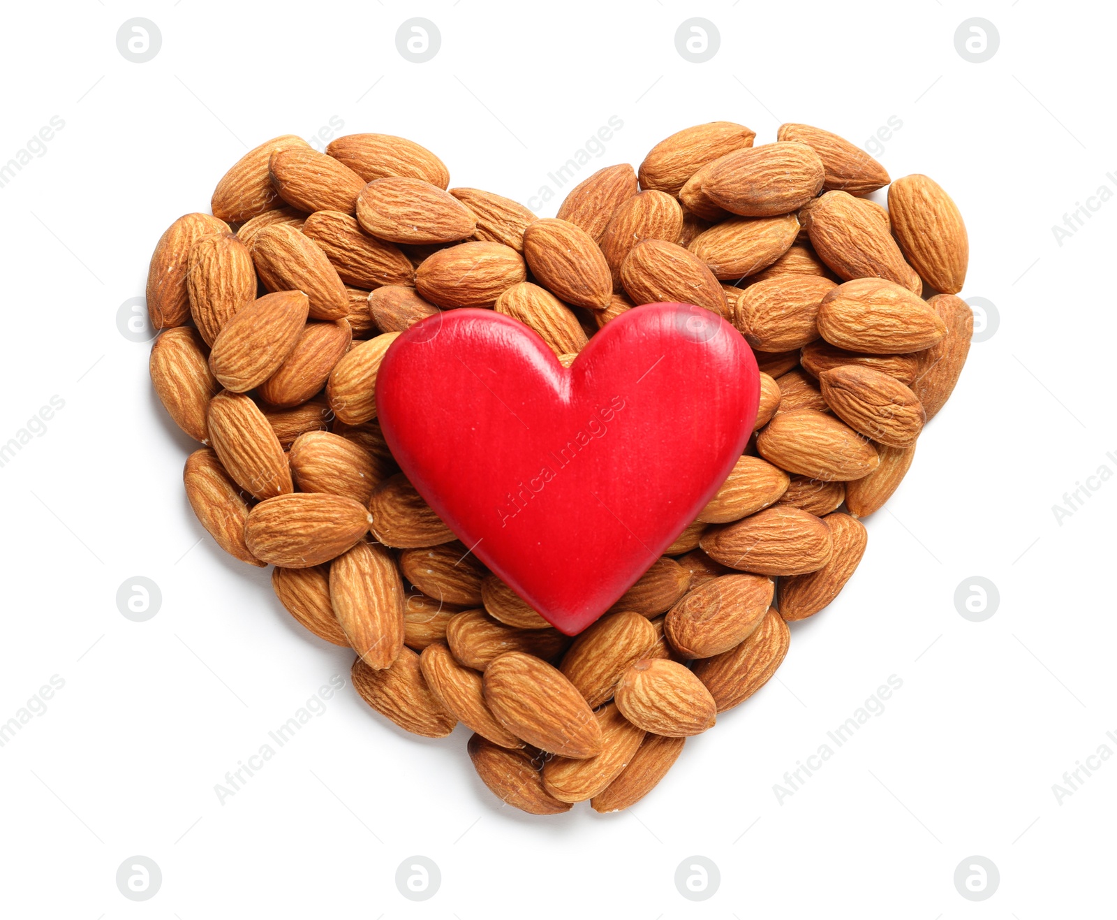 Photo of Heart made of almonds and decor on white background, top view. Healthy diet