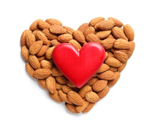 Heart made of almonds and decor on white background, top view. Healthy diet