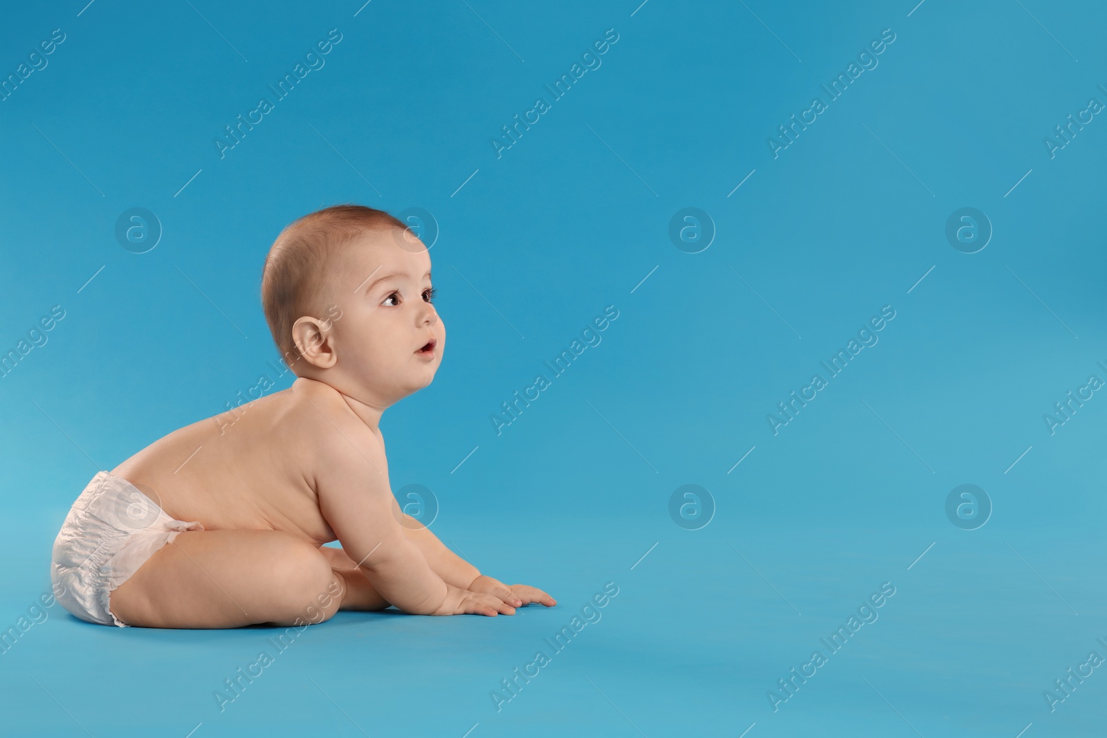 Photo of Cute little baby in diaper on light blue background. Space for text