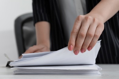 Photo of Woman stacking documents at white wooden table in office, closeup. Space for text