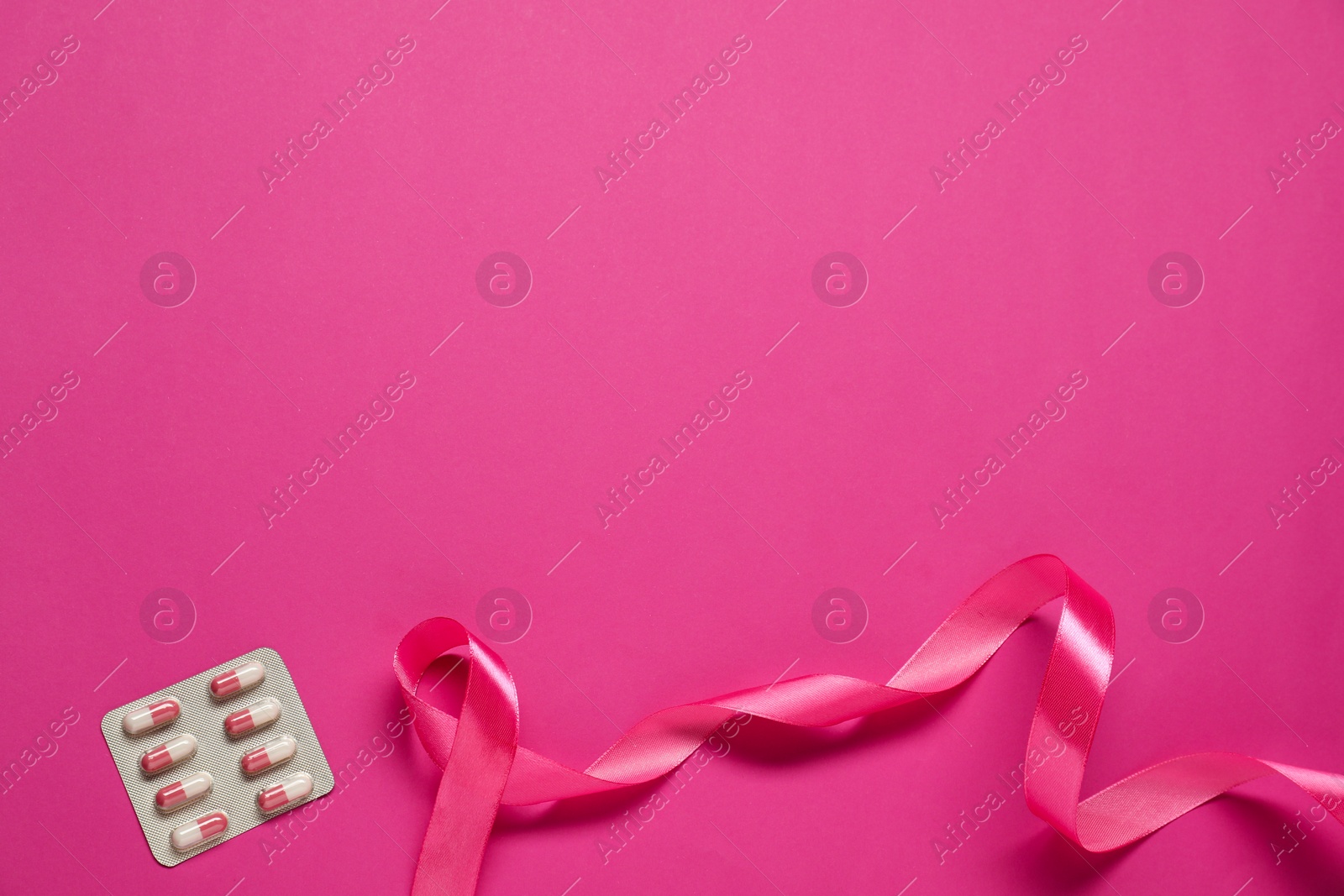 Photo of Breast cancer awareness. Pink ribbon on color background, flat lay. Space for text