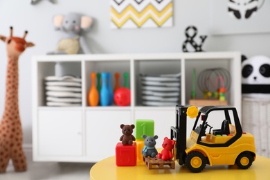 Photo of Toy stacker and cubes on table in child's room. Space for text