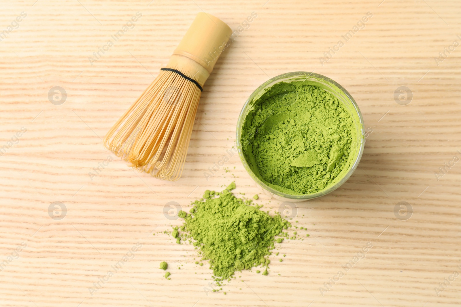 Photo of Powdered matcha tea and chasen on wooden background, top view