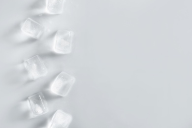 Ice cubes on light background, top view. Space for text