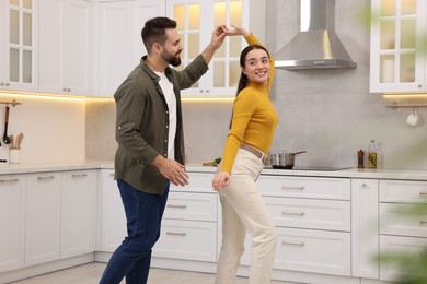 Photo of Happy lovely couple dancing together in kitchen