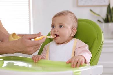 Photo of Father feeding his cute little baby healthy food at home