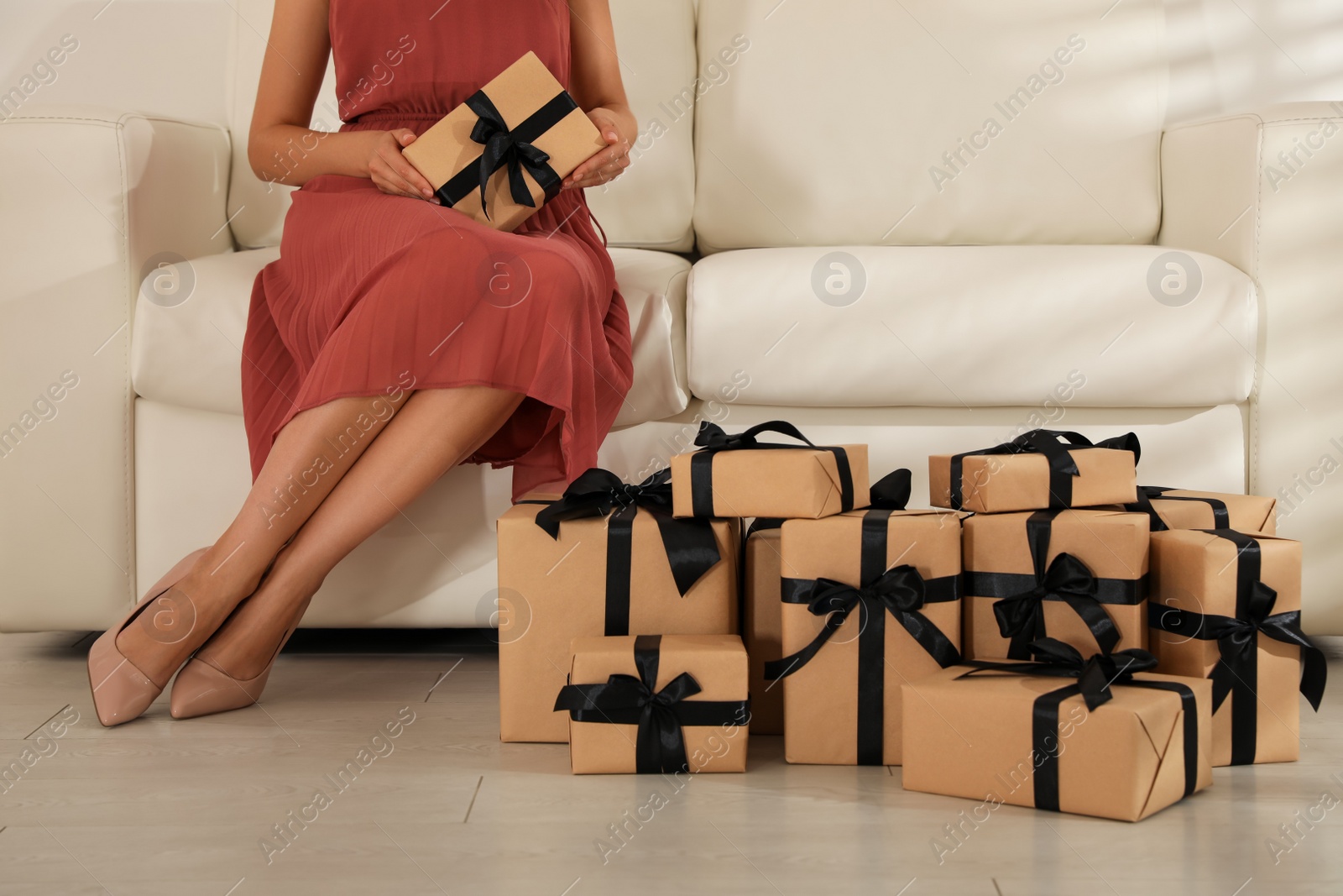 Photo of Woman with gift boxes on sofa indoors, closeup. Black Friday