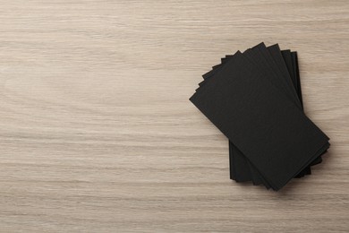 Photo of Blank black business cards on wooden table, top view. Mockup for design