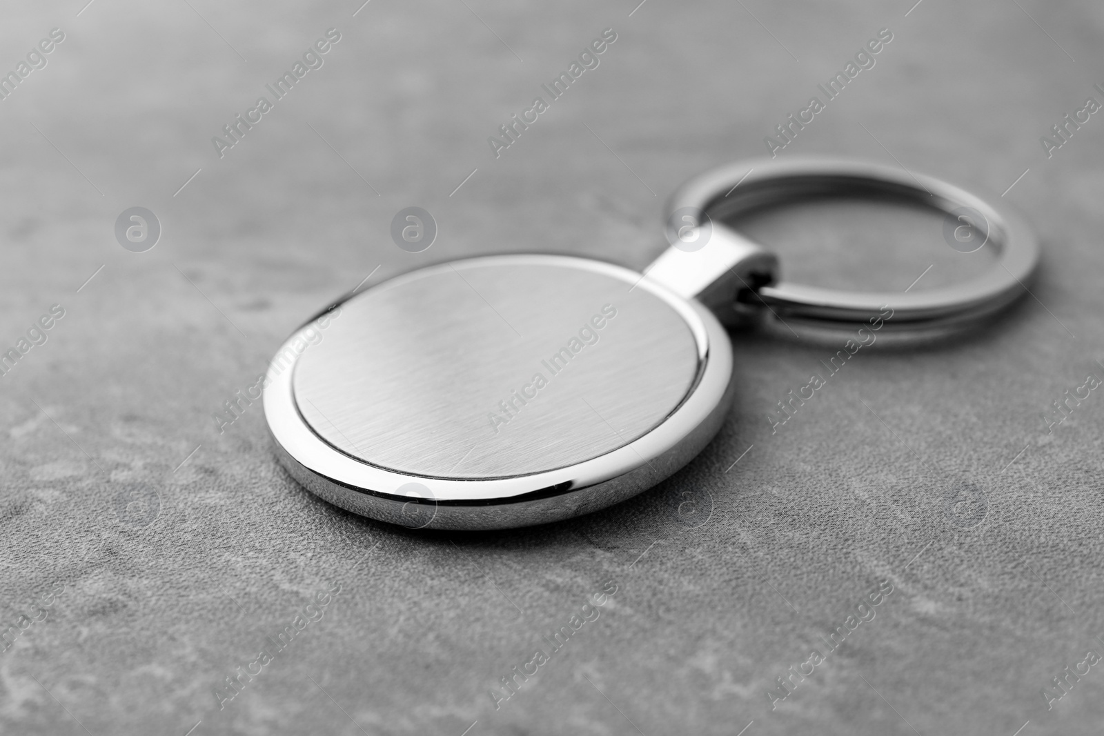 Photo of Metallic keychain on grey background, closeup view