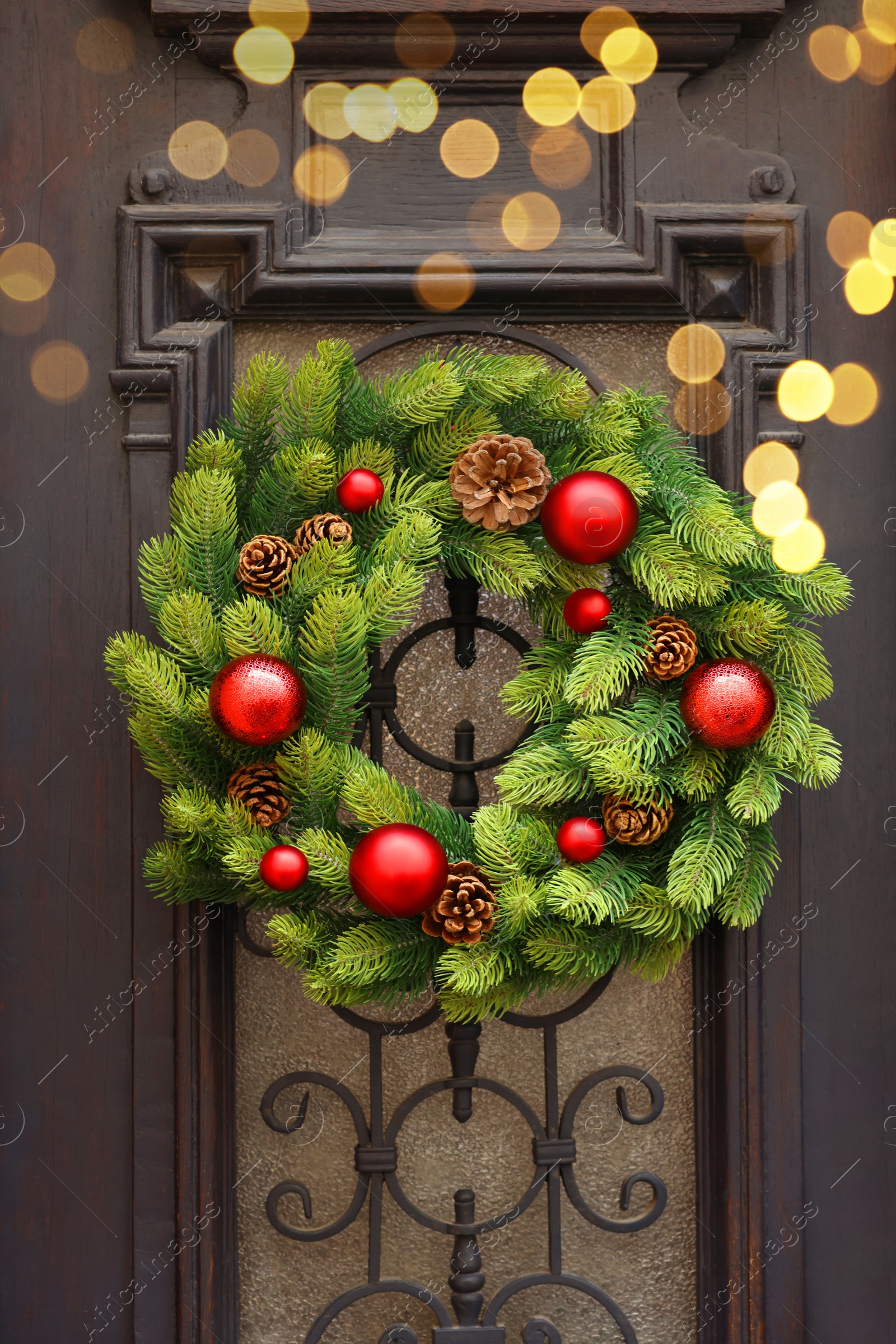 Photo of Beautiful Christmas wreath hanging on wooden door