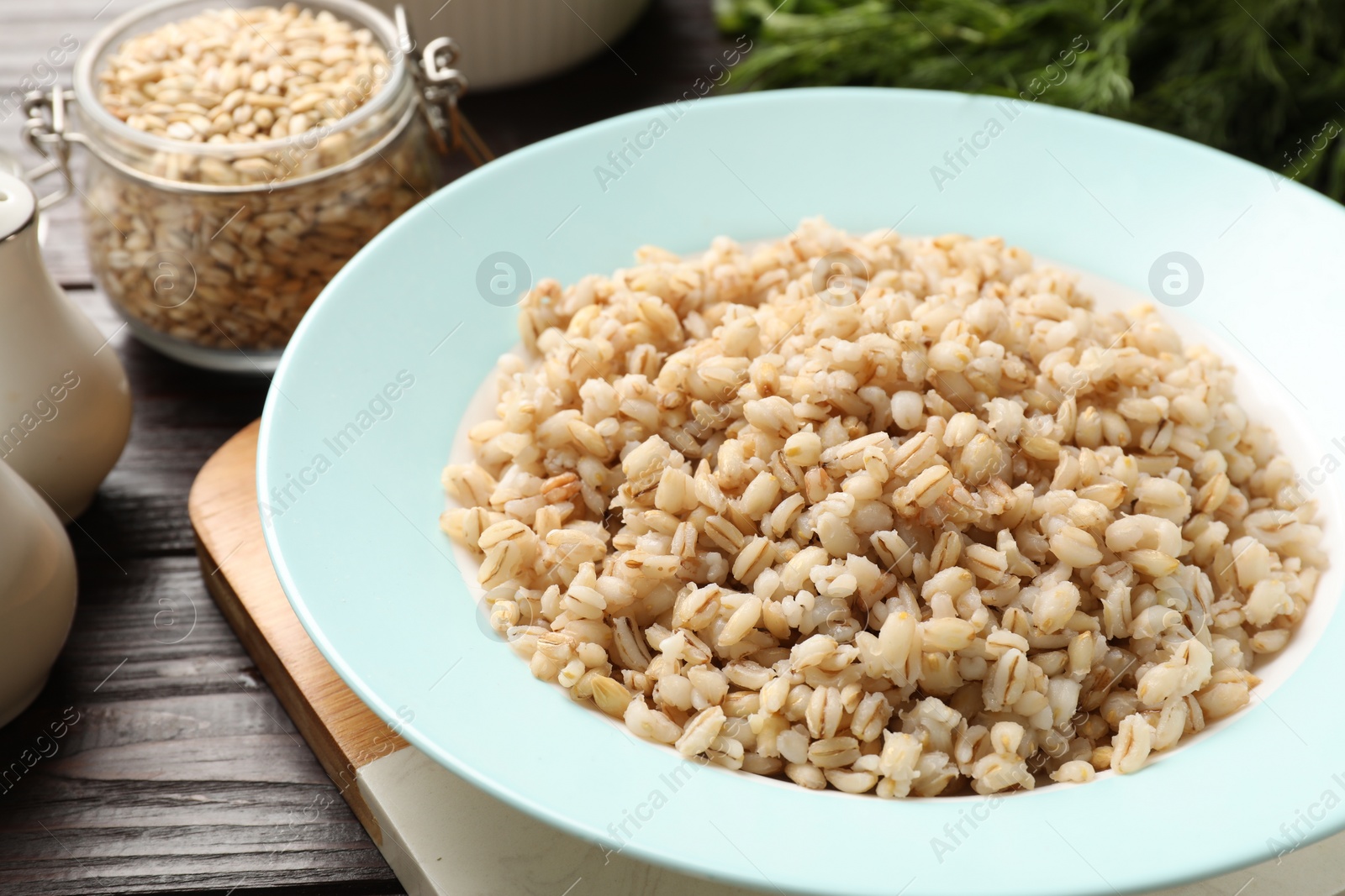 Photo of Delicious fresh pearl barley on wooden table, closeup