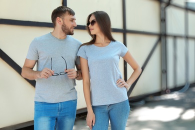 Photo of Young couple wearing gray t-shirts on street