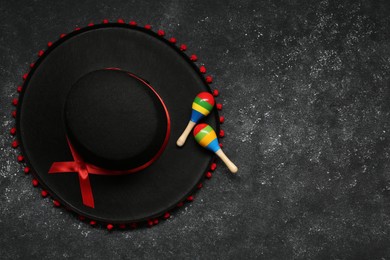 Photo of Mexican sombrero hat and maracas on grey textured background, flat lay. Space for text