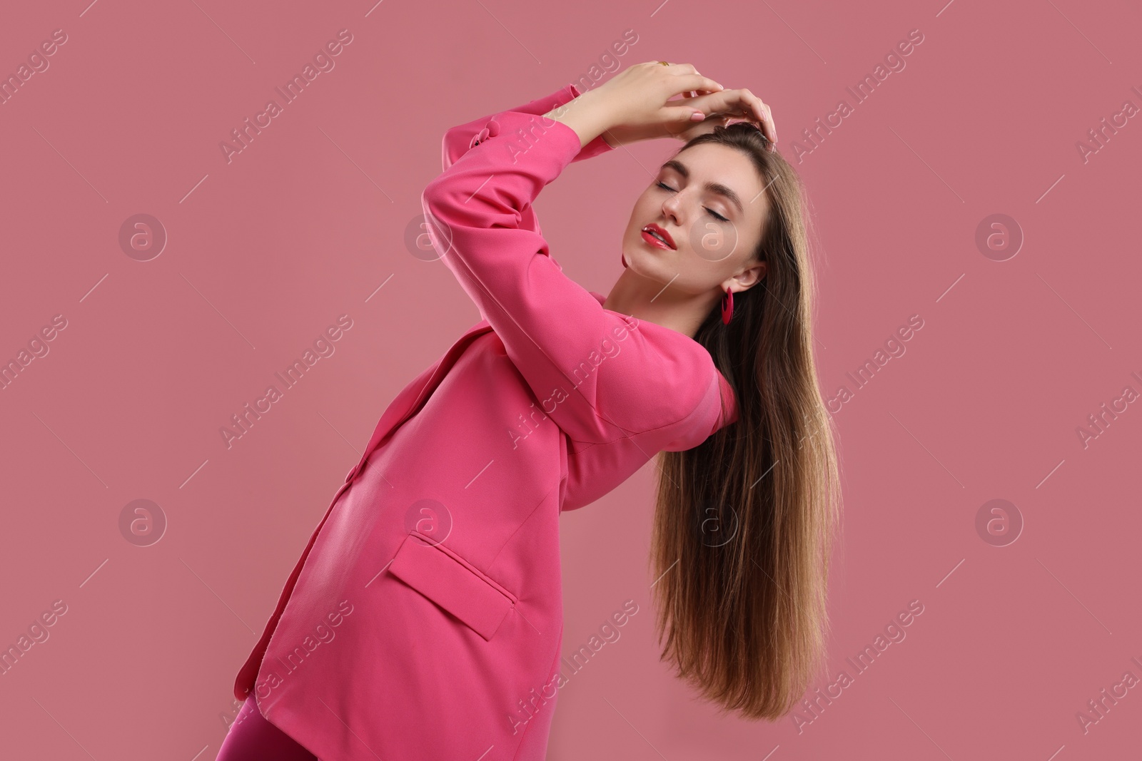 Photo of Beautiful young woman in pink clothes on color background