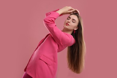 Photo of Beautiful young woman in pink clothes on color background
