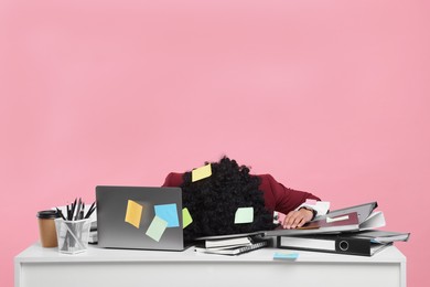 Photo of Stressful deadline. Tired woman lying on white desk against pink background, space for text. Many sticky notes everywhere as reminders