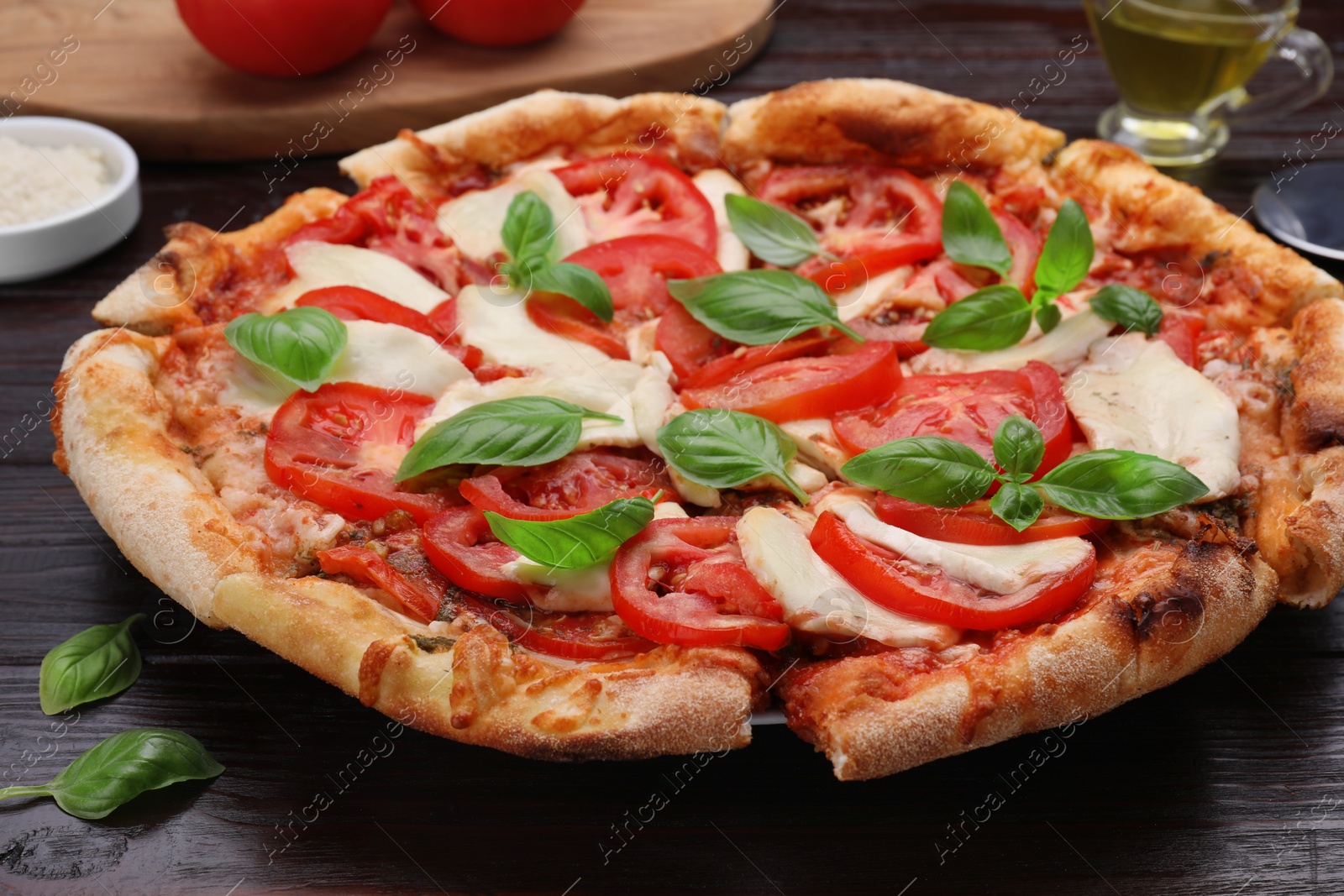 Photo of Delicious Caprese pizza on black wooden table, closeup