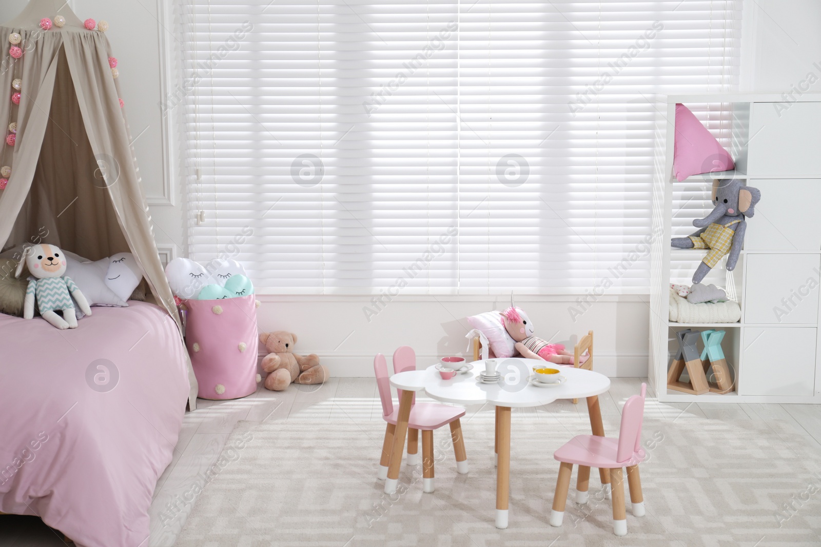 Photo of Cute child's room interior with toys and modern furniture