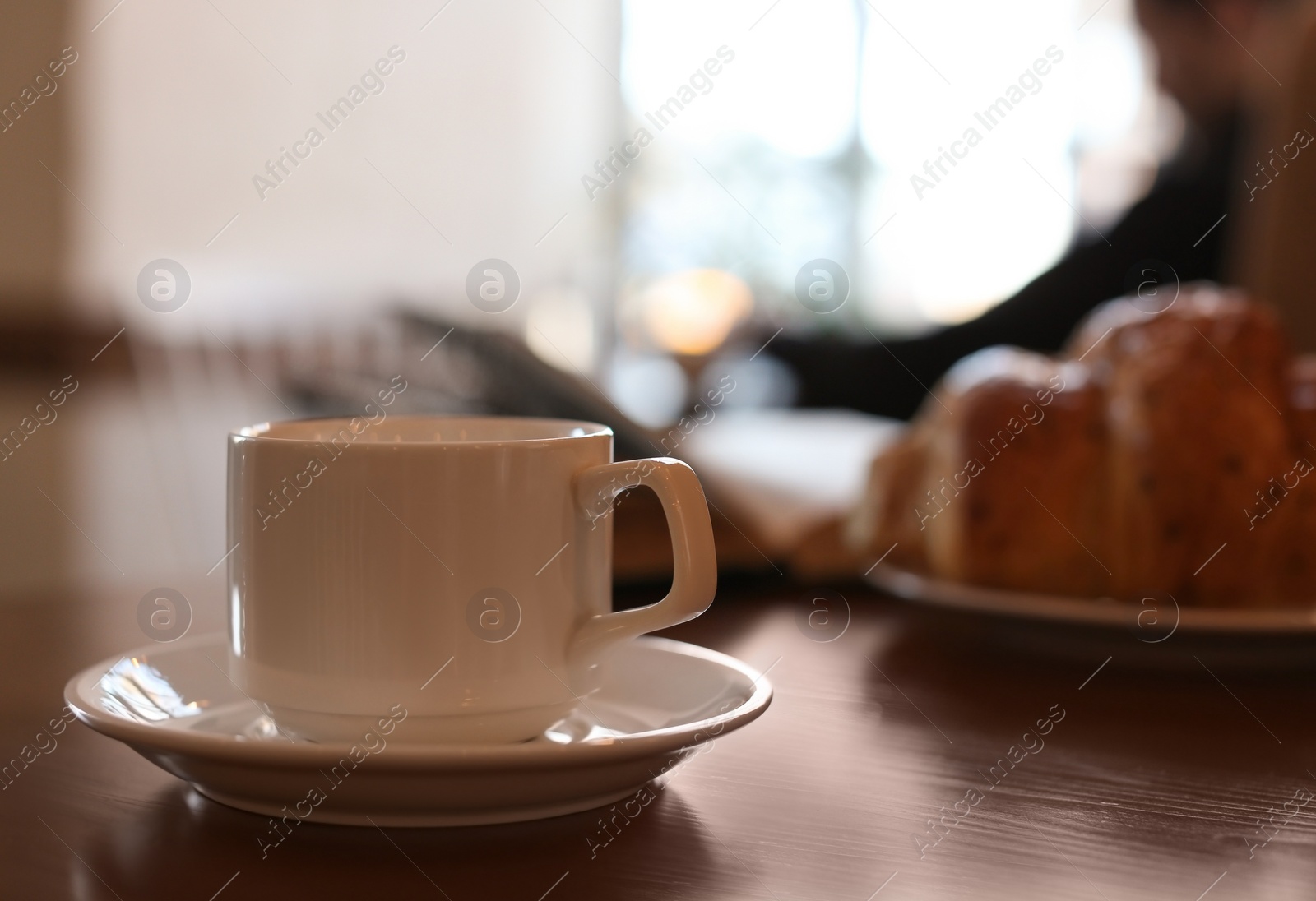 Photo of Delicious morning coffee and croissant served for breakfast on wooden table