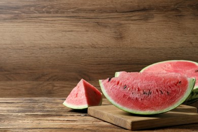 Photo of Slices of tasty ripe watermelon on wooden table, space for text