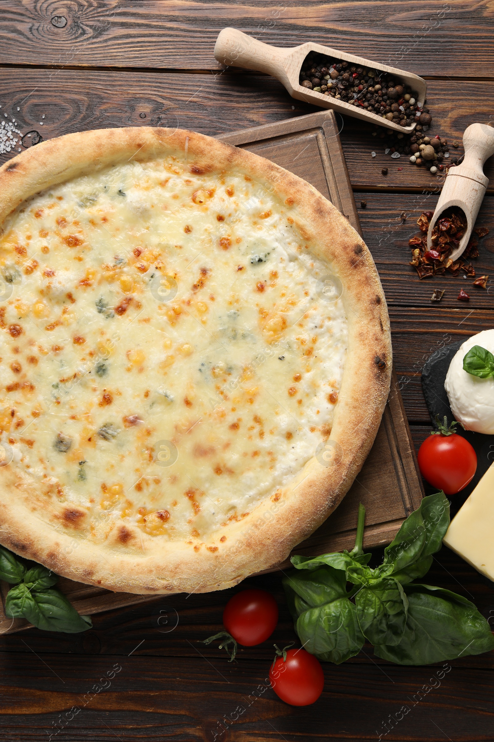 Photo of Flat lay composition with delicious cheese pizza and ingredients on wooden table