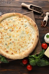 Flat lay composition with delicious cheese pizza and ingredients on wooden table