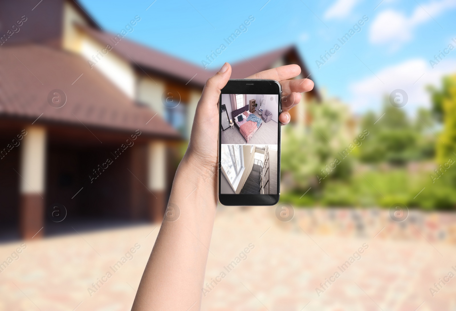 Image of Woman monitoring modern CCTV cameras on smartphone near her house, closeup. Home security system