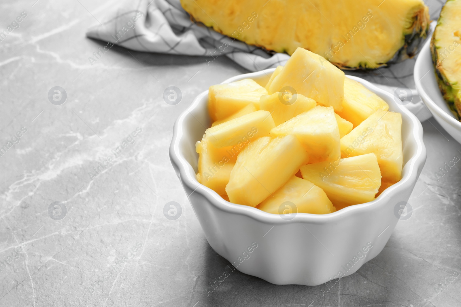 Photo of Bowl with fresh sliced pineapple on table