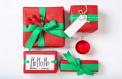 Gift boxes and Christmas ball on white background, flat lay