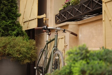 Bicycle parked near building with green plants