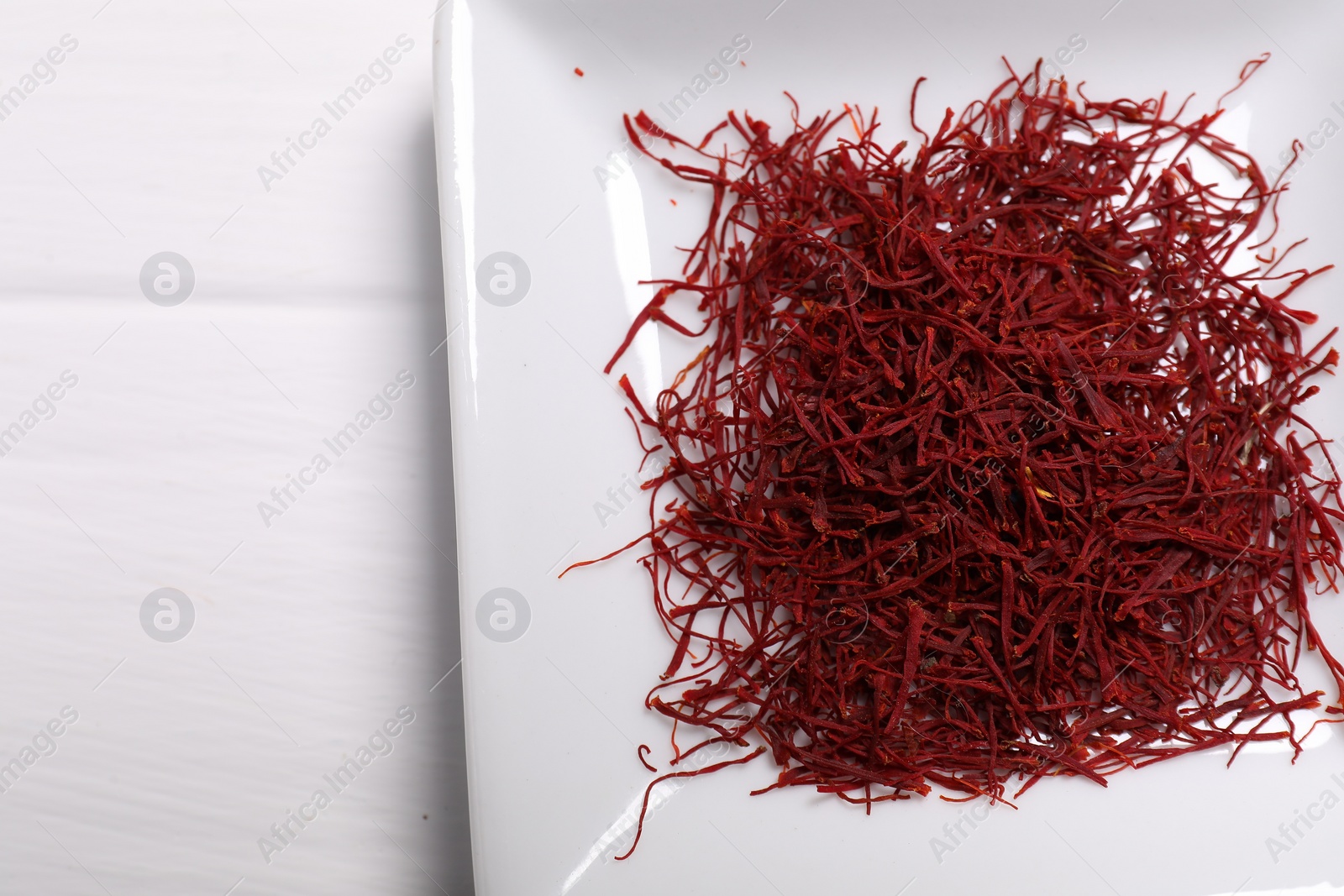 Photo of Aromatic saffron on white table, top view. Space for text