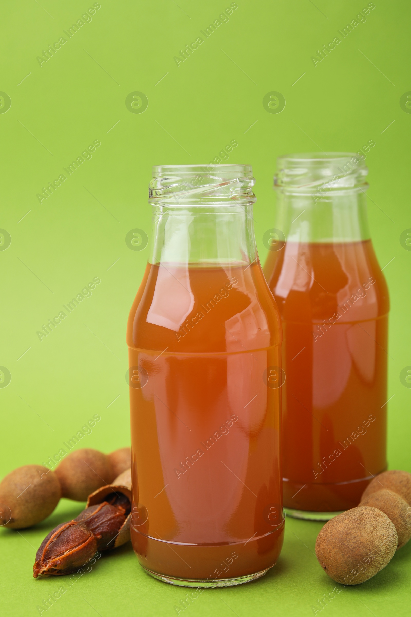 Photo of Tamarind juice and fresh fruits on green background
